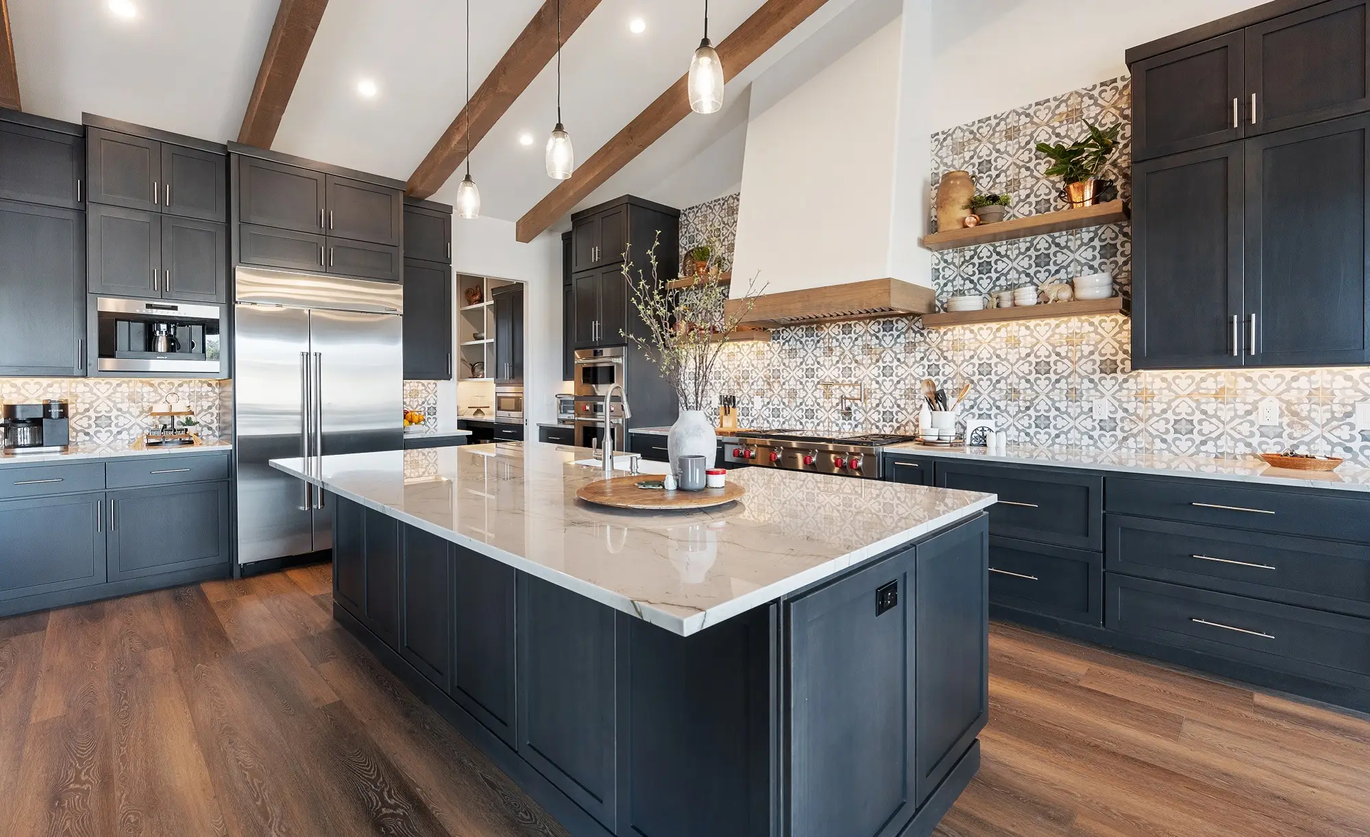 Remodeled kitchen with dark shaker cabinets, a marble-topped island and a patterned tile backsplash