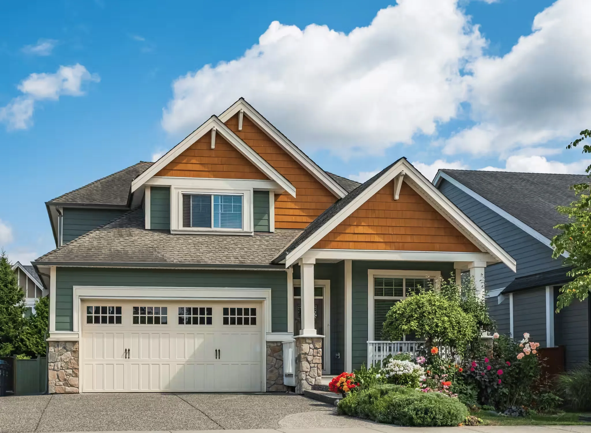 Craftsman-style house with green lap siding and cedar shake gables